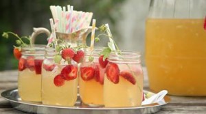 Glasses filled with switchel and fresh strawberries